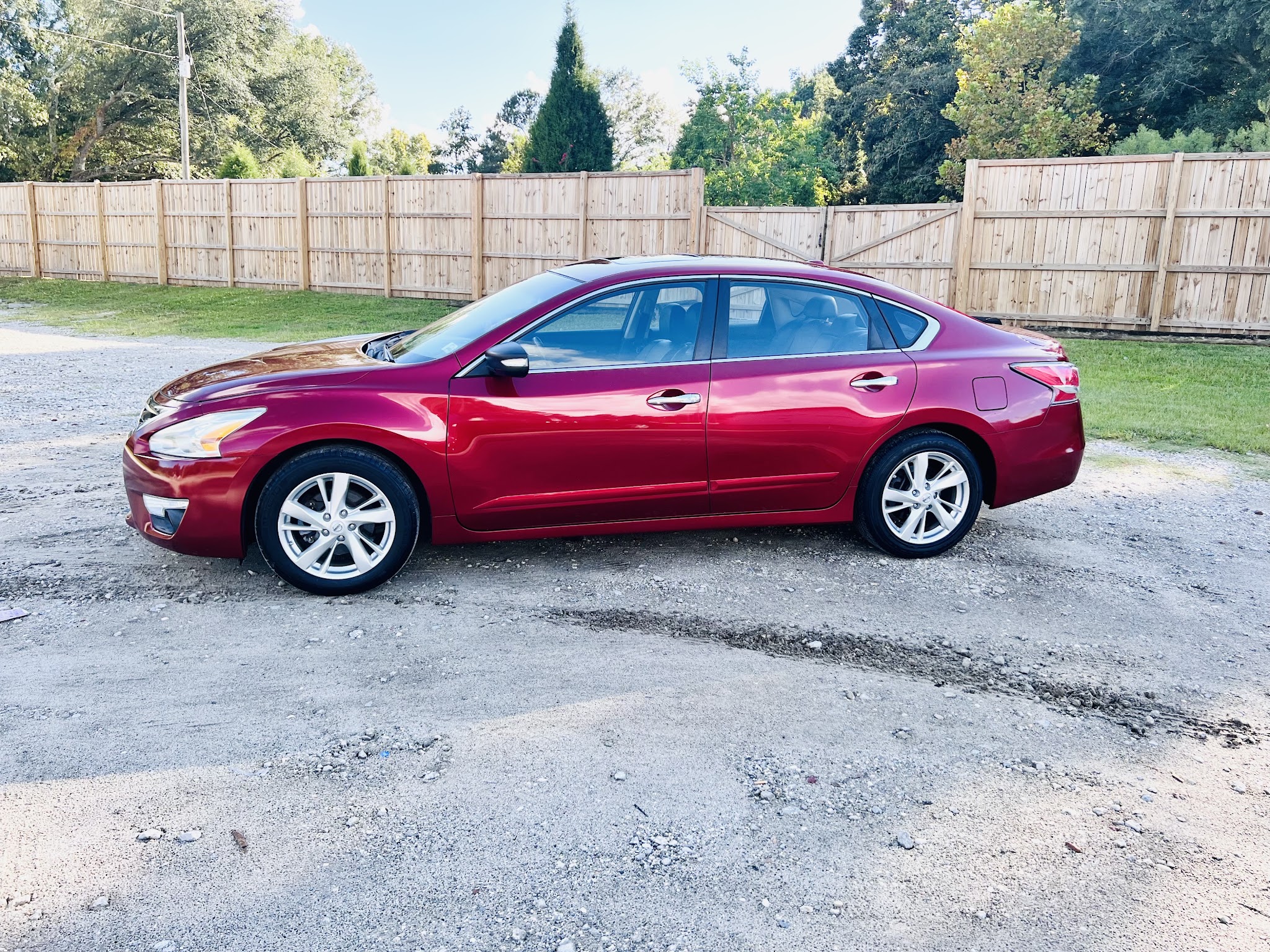 A red Nissan sedan parked on our lot in Ladson