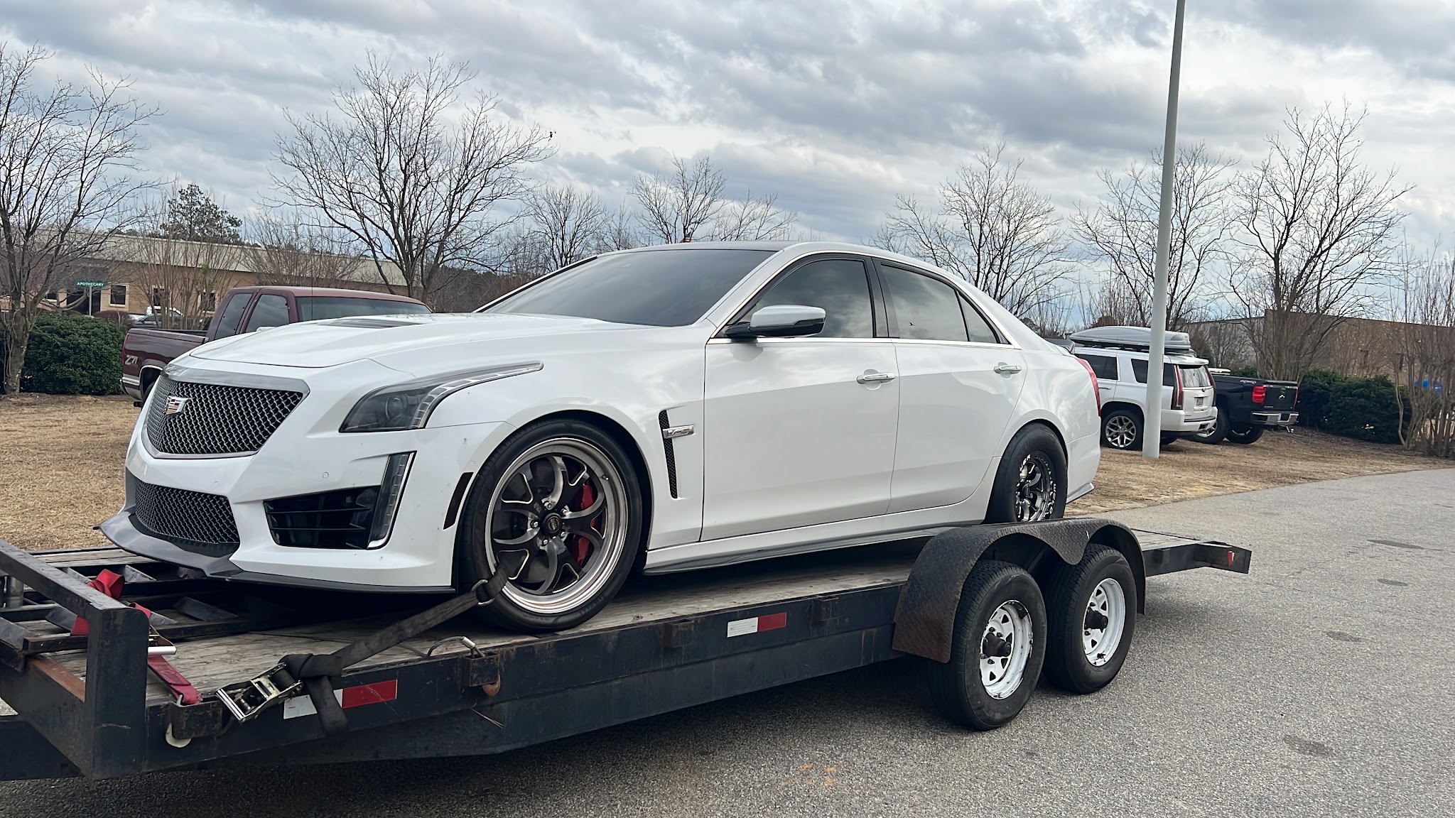 A white sedan strapped down on our car trailer